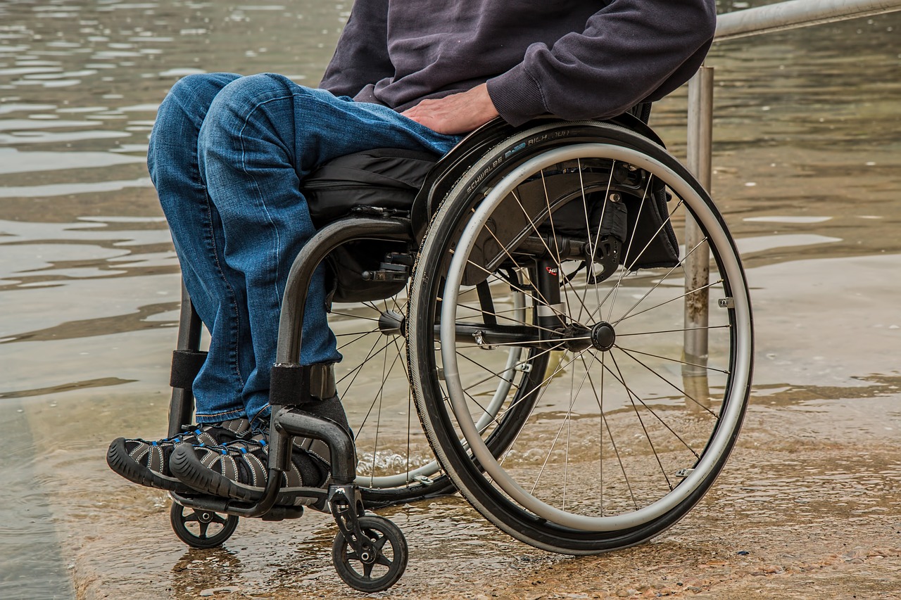 Picture of a person using a manual wheelchair at the side of a pond